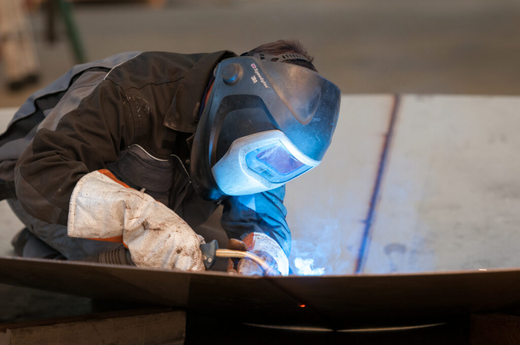 Soudeur en train de souder une pièce d'inox – article sur inox 304 ou 316 par Le Garrec